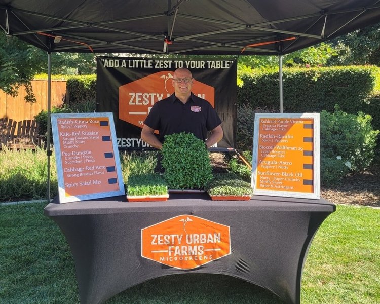 John from ZestyUrbanFarms at a sales booth outside